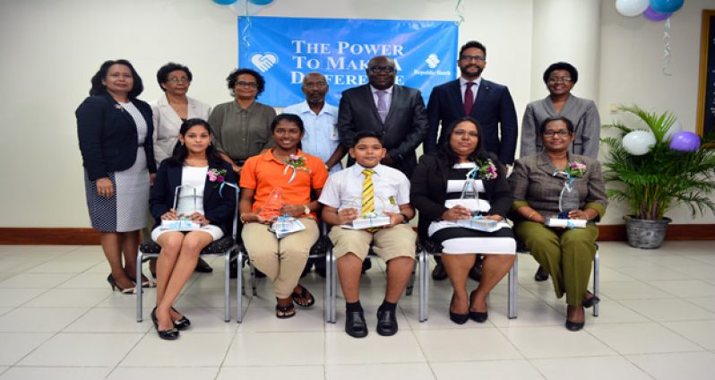 Second and third from right (standing)   Managing Director, Republic Bank (Guyana) Ltd,  Richard Sammy and Deputy Chief Education Officer  Marcel Hudson, along with senior managers of Republic Bank and the University of Guyana pose with the awardees at yesterday’s Achievement Awards Ceremony.