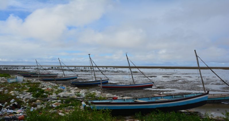 Boats stalled at Better Hope beach are surrounded by garbage