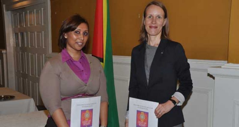 Canadian High Commissioner, Dr. Nicole Giles (right) displaying the Rotary insignia and certificate after the induction ceremony