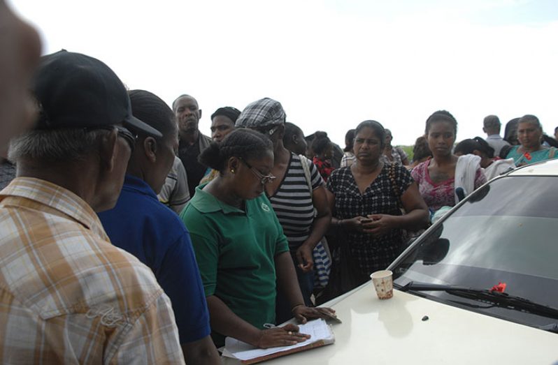 An employee of the GPS surrounded by persons who were trying to send food into their relatives (Delano Williams photo)