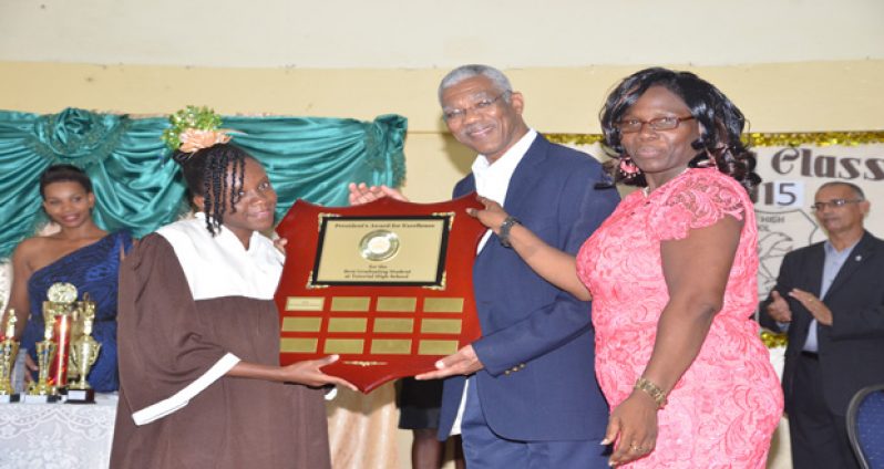 Valedictorian LaTonya Browne receives the ‘President’s Award for Excellence’ from President David Granger as Tutorial Headteacher Walterine McCloud assisted, in the presence of her fellow graduates