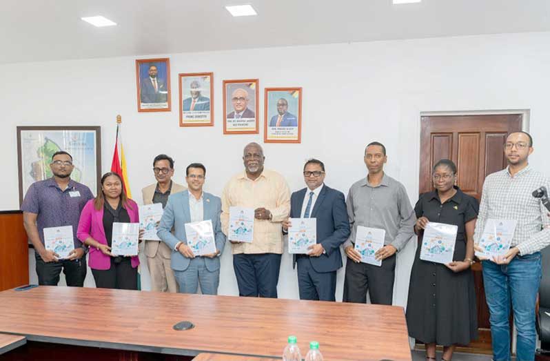 Prime Minister, Brigadier (Ret'd) Mark Phillips and the Minister of Public Utilities and Aviation, Deodat Indar, flanked by other officials on Wednesday, officially received Guyana's Demand Side Management (DSM) Action Plan