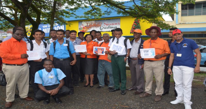 Social Protection Minister Volda Lawrence backed by a group of men, calling for an end to Domestic Violence