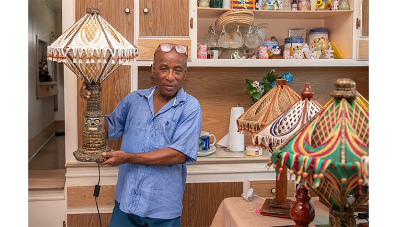 Claudius Henry poses with one of his hand-made lamps