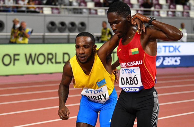 Guinea-Bissau's Braima Suncar Dabo helps Aruba's Jonathan Busby to finish the race. (REUTERS/Dylan Martinez)