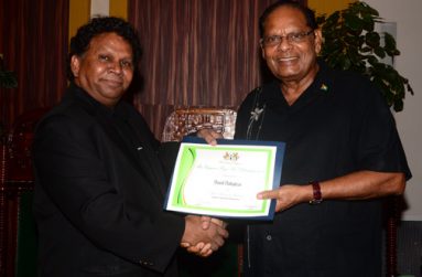 David Dabydeen receiving his prize last Sunday from Prime Minister Moses Nagamootoo