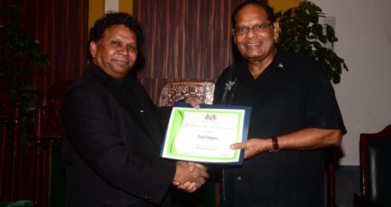 David Dabydeen receiving his prize last Sunday from Prime Minister Moses Nagamootoo