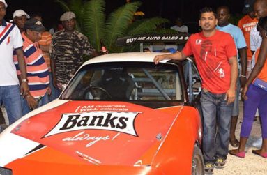 Danny Persaud (right) is seen with his Mazda Miata and motor racing fans at a recent event.