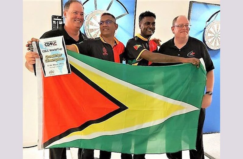 Norman Mahdoo (2nd left) and Sudesh Fitzgerald are flanked by Darts officials after they qualified for the World Cup of Darts in Germany