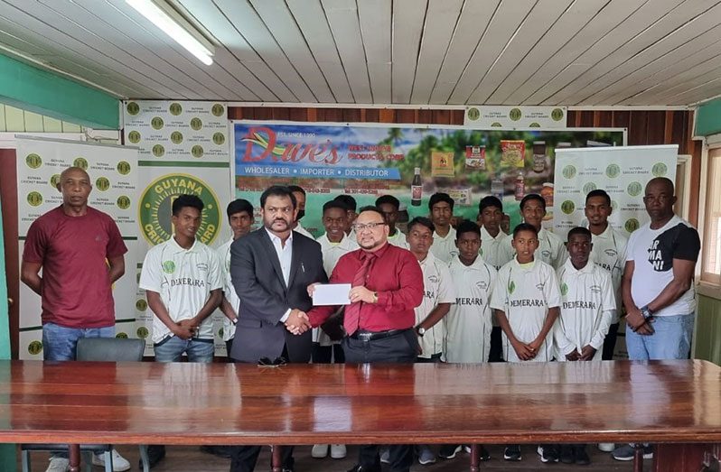 Flanked by Under-15 players, GCB president Bissoondyal Singh (at right) accepts the sponsorship cheque from Dave Narine ahead of today's opening of the tournament.