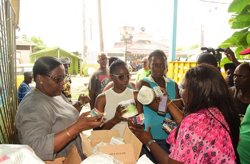 Minister within the Ministry of Natural Resources Simona Broomes, distributes much-needed supplies to the victims of Friday’s fire (Adrian Narine photo)