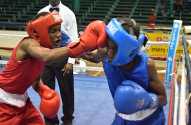 Delroy Elcock (left) and Joel Allicock exchange punches during their junior flyweight contest at the Cliff Anderson Sports Hall on Friday evening (Cullen Bess-Nelson photo).