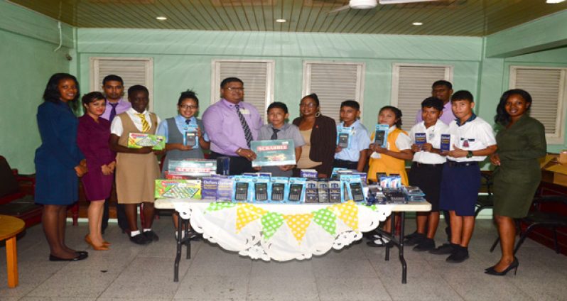 Representatives of Demerara Bank Ltd, senior social worker Rosamund Daly (seventh left) pose with students during the presentation ceremony (Photo by Adrtian Narine)