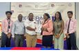Oceola Van Doimen, Sales and Marketing Coordinator of Demerara Mutual making a presentation to Petra Director Troy Mendonca, flanked by staff of both companies