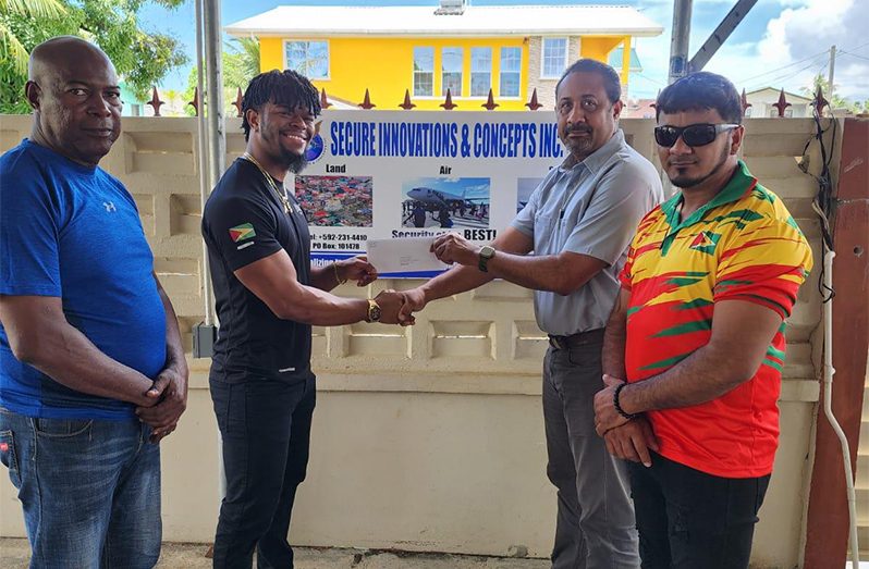 SIC Inc. Aviation Security Manager, Mr. Denzel Hopkinson (2nd left) hands over the cheque to Captain Dylan Fields in the presence of Lennox Brathwaite (left) and Roberto Tiwari.