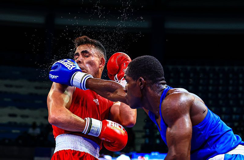 Guyana’s Demond Amsterdam (right) connects to HectorAguirre of Mexico  during their middleweight semi-final bout at the AMBC Championships in Ecuador