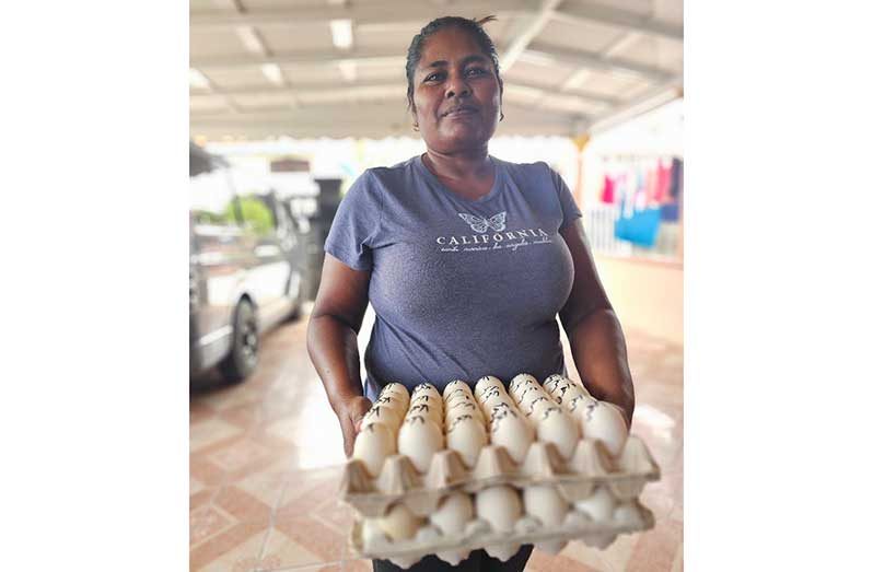 Kalawattie Mangal poses with her duck eggs, which she picked up from her pens
