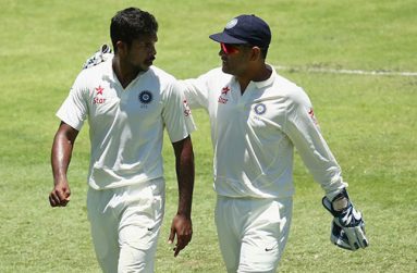 MS Dhoni (right) talks to his fast bowler Varun Aaron as India go to pieces during the second Test match against Australia in Brisbane. (Getty Images)