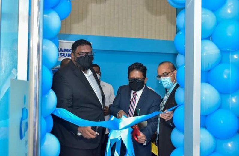President Dr Irfaan Ali and Finance Minister Dr Ashni
Singh cuts the ceremonial ribbon to officially
open the Diamond Insurance branch at Mahaica,
East Coast Demerara