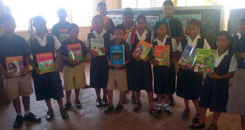 Hobodeia Primary pupils display the books they received from DIGICEL