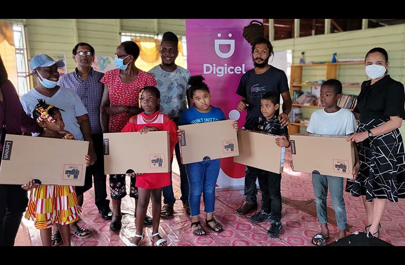 Digicel’s Chief Commercial Officer, Simone Pierre (far right) stands with children and members of the Community Open Door Alliance during the donation