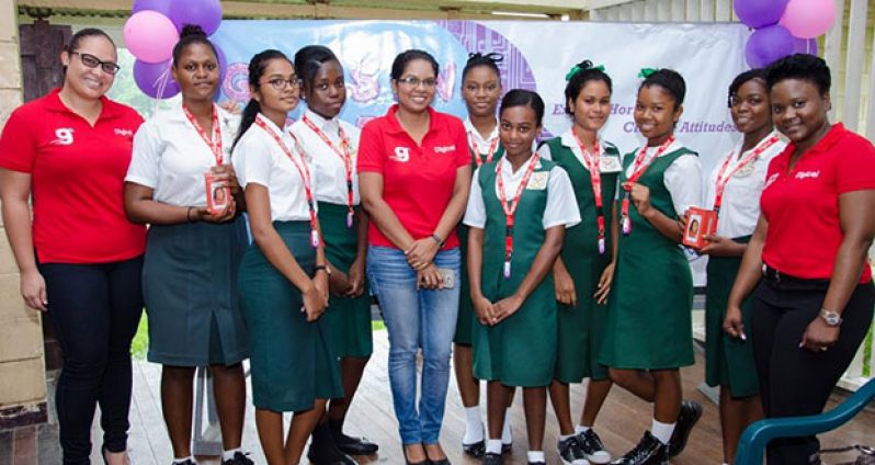 Digicel Guyana Public Relations Manager Vidya Bijlall-Sanichara and other staffers pose with pupils of Bygeval Secondary School with their flash drives,  compliments of Digicel yesterday during the symposium