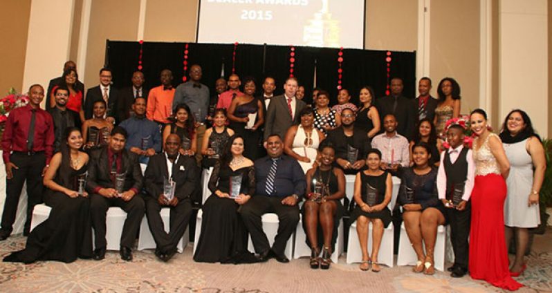 Awardees posing with their plaques flanked by Digicel’s CEO Kevin Kelly and other senior managers and staffers on Saturday night at Marriott Hotel