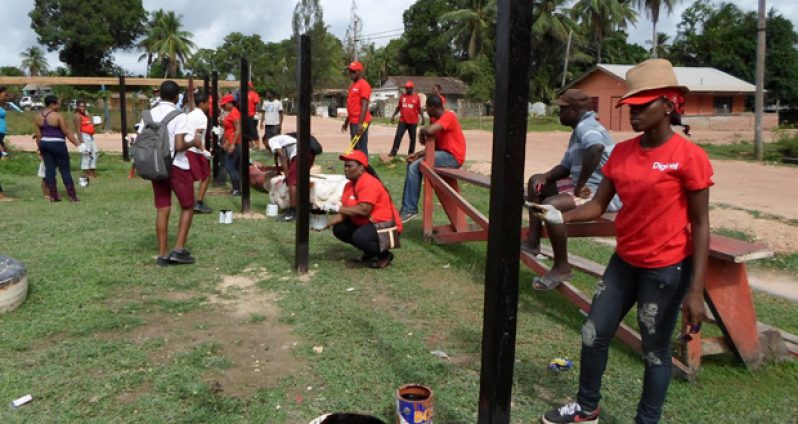 Digicel staffers as they assist in the construction of the fence for the basketball court at Kwakwani.