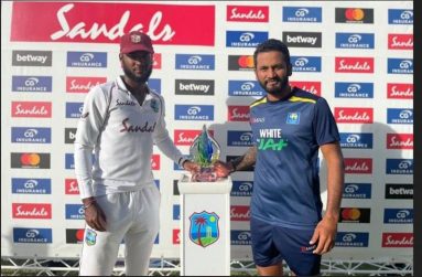 West Indies captain Kraigg Brathwaite  (left) and Sri Lanka captain Dimuth Karunaratne pose with the series trophy after their team drew the second Test in Antigua. (Photo courtesy CWI Media)