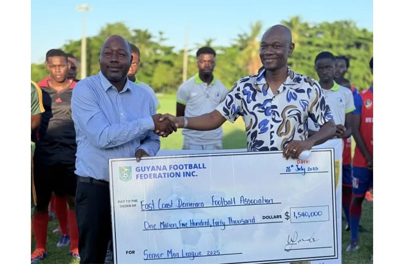 GFF Third Vice-President, Dion Innis (right) makes the presentation to a representative of the East Coast Demerara Football Association.