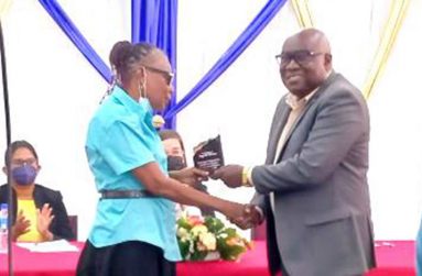 Chief Education Officer Marcel Hutson honours Ingrid Peters for being the longest-serving blind educator in Guyana