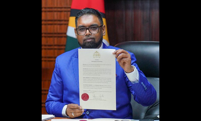 President, Dr. Irfaan Ali holds the Instrument of Accession for the Treaty Establishing the Regional Security System (Office of the President)