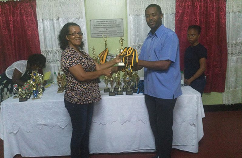 Mayor Holland at left hands over trophies and medals to Mary Chung-Phillips
