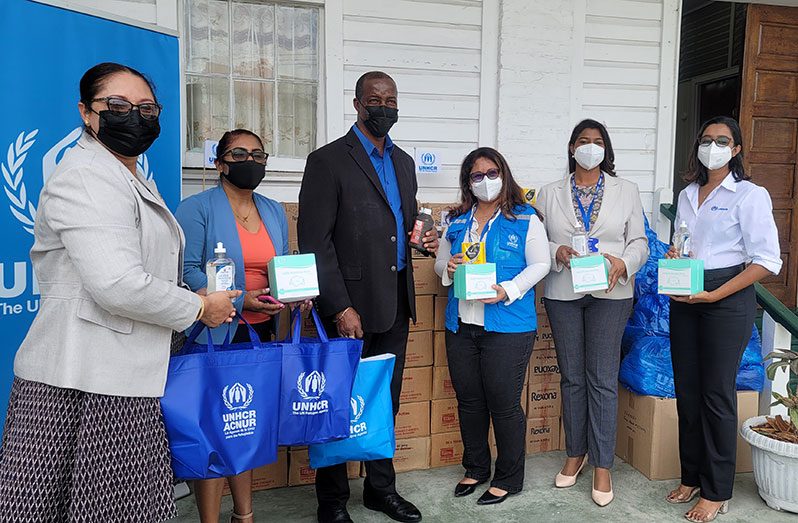 UNHCR representatives hand over cleaning supplies and protective equipment to officials of the Ministry of Education (UNHCR/ Syed Mazhar photo)