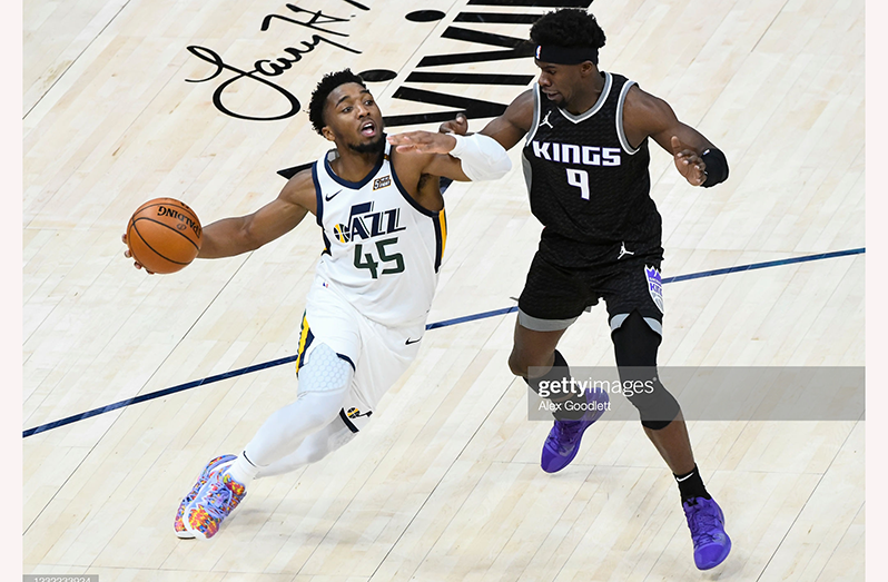 Donovan Mitchell (#45) of the Utah Jazz drives into Terence Davis (#9) of the Sacramento Kings during a game at Vivint Smart Home Arena on April 10, 2021 in Salt Lake City, Utah. (Photo by Alex Goodlett/Getty Images)