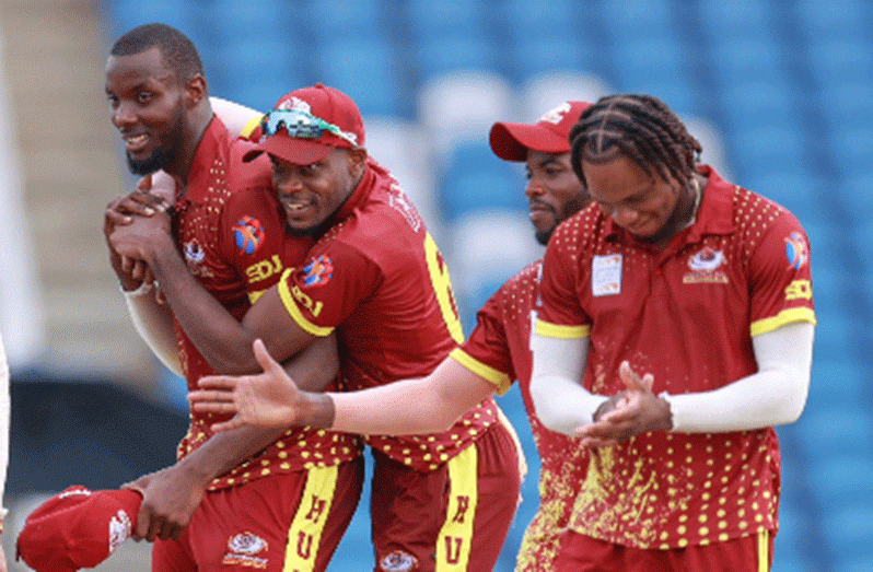 Left-arm spinner Daniel Doram (left) is surrounded by teammates after grabbing another wicket during his seven-wicket haul (Photo courtesy CWI Media)