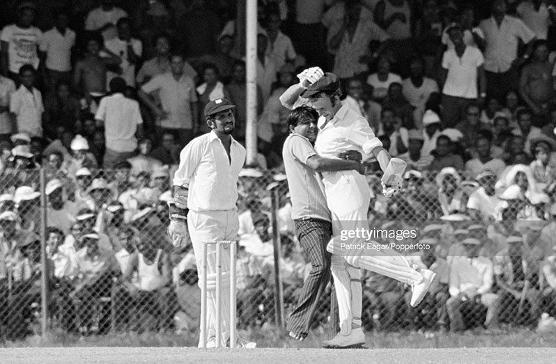 Flashback: Doug Walters of Australia gets a hug from a spectator during his innings of 112 in the 3rd Test match between West Indies and Australia at Queen's Park Oval, Port of Spain, Trinidad, 23rd March 1973. The wicketkeeper for West Indies is Deryck Murray. Australia won the match by 44 runs. (Photo by Patrick Eagar/Popperfoto via Getty Images)