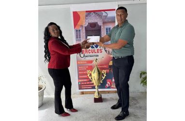 General Manager of Hercules Construction Services, Ms. Okeisha Douglas hands over the sponsorship cheque to Kashif and Shanghai Co-Director, Kashif Muhammad
