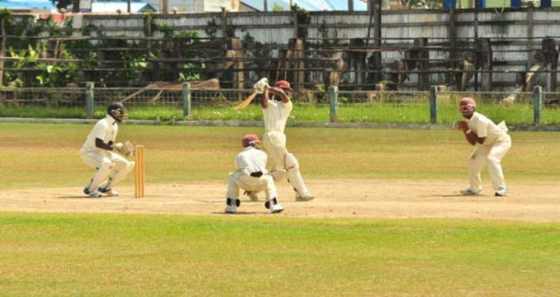 Singh’s XI Shimron Hetmyer goes down the ground during his robust half-century yesterday before his dismissal, as Robin Bacchus (right), Rajendra Chandrika (backing camera) and wicketkeeper Anthony Bramble look on.