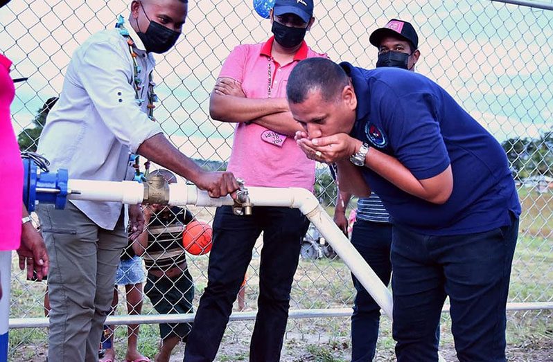 Housing and Water Minister Collin Croal, drinks  water from the well after the commissioning of the $42M water-supply system in Jawalla