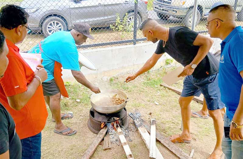 Divisional Commander, Assistant Commissioner Khali Pareshram (extreme right) with CDC Chairman, Dr. R. Tularam, during the judging of the duck curry cook-off