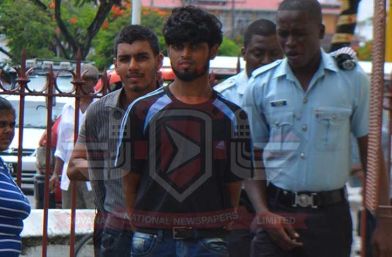 Michael Sookoo and Avishkar Rambarran (behind) exit the Georgetown Magistrates’ Court.