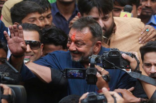 Sanjay Dutt waving to fans yesterday as he arrived at his residence in Mumbai after being released from jail