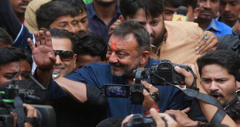 Sanjay Dutt waving to fans yesterday as he arrived at his residence in Mumbai after being released from jail