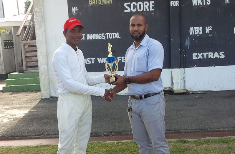 GCB representative Anthony D’Andrade presents the winner’s trophy to Friendship Secondary 
Captain, Orlando Ghisiawan