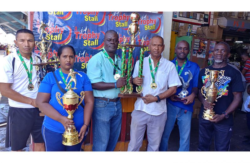 Trophy Stall Managing Director, Ramesh Sunich (3rd right) hands over the winner’s trophy to EBFA president, Kevin Anthony, at the Bourda Market location. Other executive members share the moment.