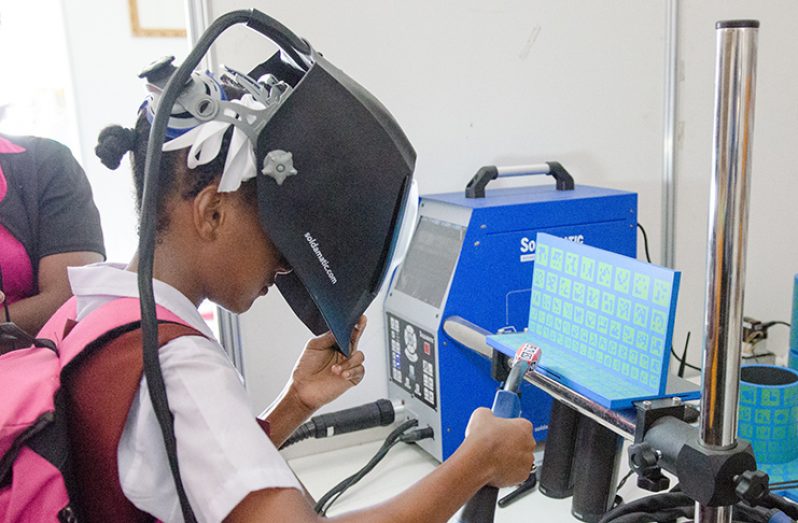 Student testing the Welding Simulator of the Leonora Technical Institute at the exposition.