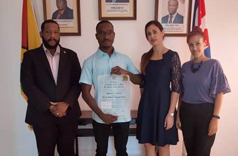 (From left) Quincy Younge, Foreign Service Officer, Guyana Embassy; Keron Niles displaying his academic certificate; Ms. Mayte Perdomo, Confidential Secretary to the Guyana Ambassador; and Ms. Arlenys Ponce, Administrative Officer (Trade)