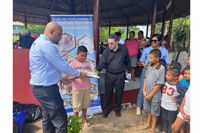 ERC Chairman Shaikh Moeenul Hack (centre) flanked by Head of Public Education and Awareness, Dwijendra Rooplall (extreme left) and CEO Ms. Gomin Camacho (right) sharing gifts to children of the Moruca Sub District of Region One, Barima-Waini