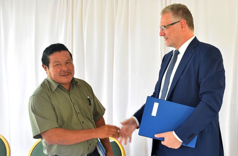 EU Ambassador to Guyana, Jernej Videtic (right), exchanges a handshake with APA leader, Mario Hastings, following the signing of the agreement at the Promenade Gardens on Wednesday